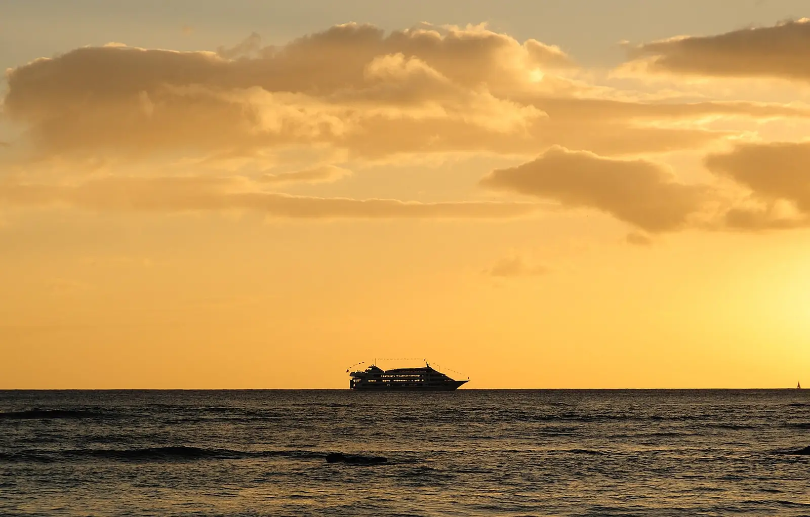 夕日の海に浮かぶサンセットクルーズの船
